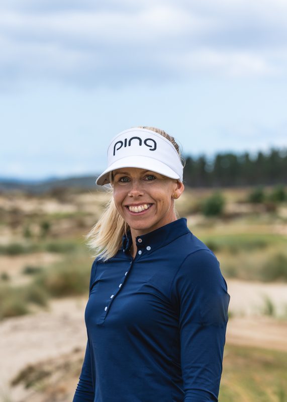 Pernilla Lindberg smiling in a white PING visor and navy top